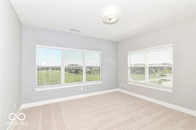 unfurnished room with visible vents, baseboards, and carpet floors