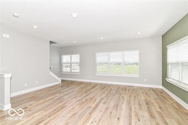 spare room featuring recessed lighting, light wood-style flooring, and baseboards