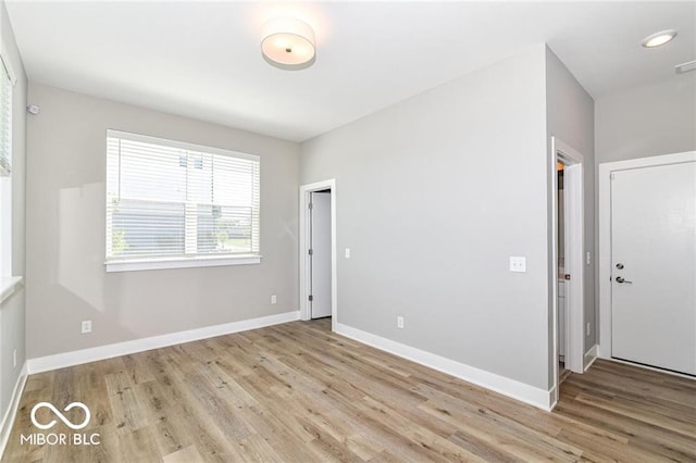 empty room with visible vents, baseboards, and wood finished floors