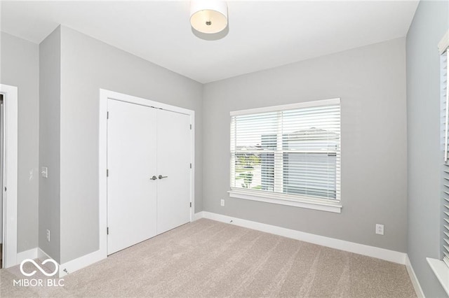 unfurnished bedroom featuring a closet, baseboards, and carpet