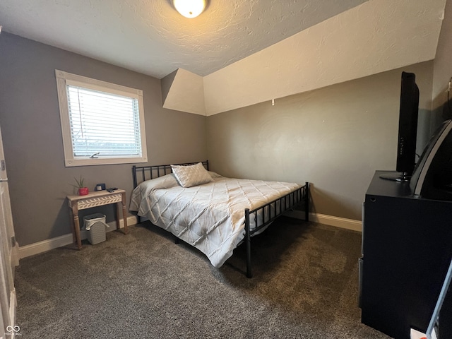 bedroom featuring baseboards, dark carpet, and a textured ceiling