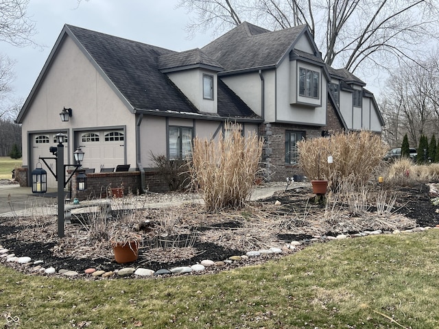 view of side of property featuring stucco siding, brick siding, roof with shingles, and an attached garage