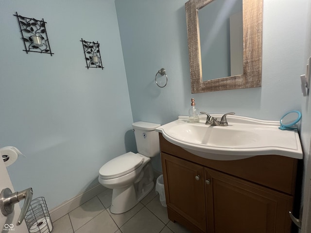 bathroom with tile patterned flooring, toilet, vanity, and baseboards