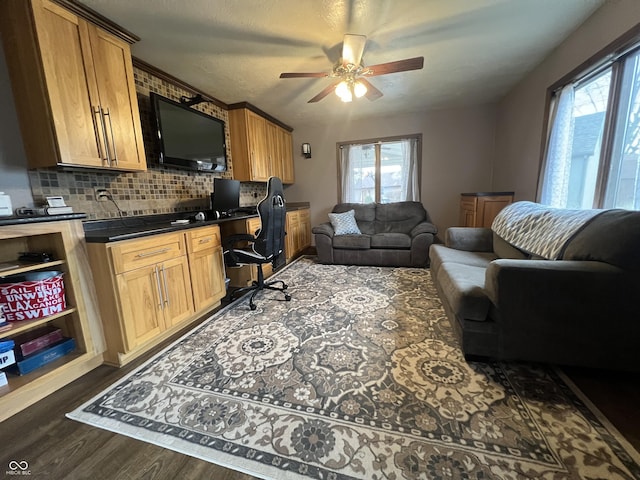 living room with dark wood-type flooring and ceiling fan