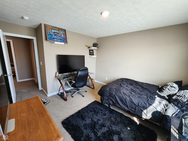 bedroom featuring a textured ceiling, baseboards, and carpet