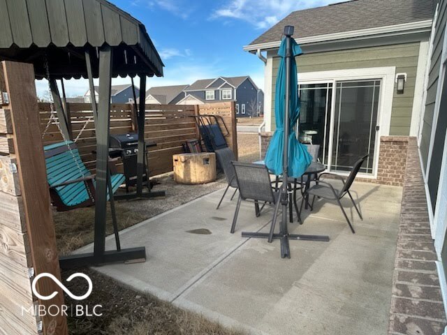 view of patio featuring outdoor dining space and fence