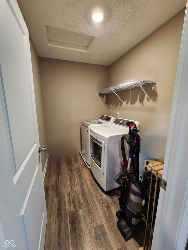 washroom featuring dark wood-type flooring, attic access, laundry area, washer and dryer, and a textured ceiling