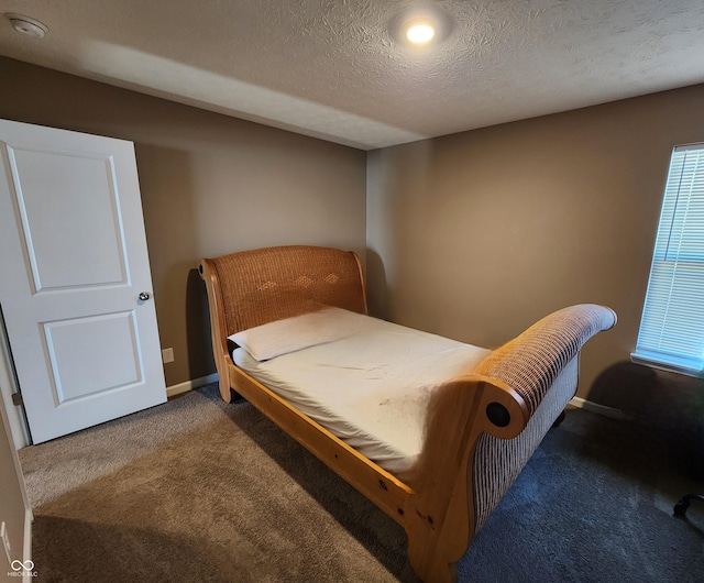 bedroom with carpet, baseboards, and a textured ceiling