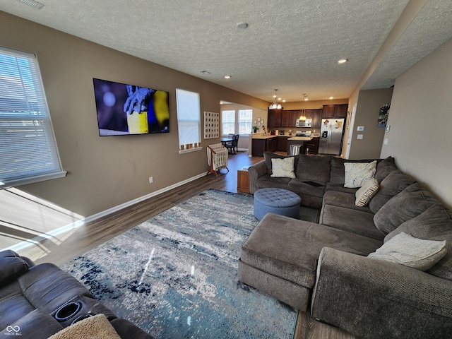 living room with visible vents, baseboards, recessed lighting, a textured ceiling, and dark wood-style flooring