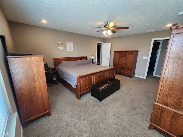 bedroom with visible vents, a textured ceiling, baseboards, light colored carpet, and ceiling fan