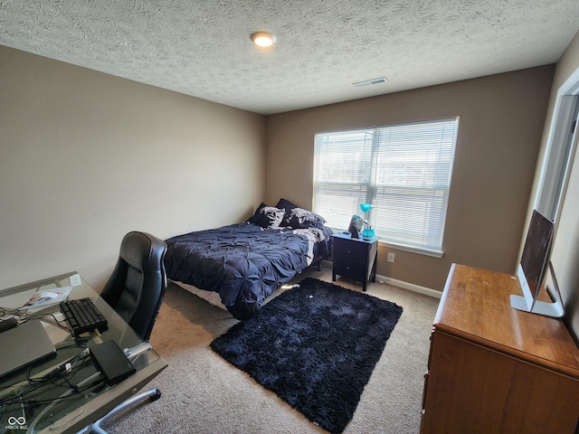 bedroom featuring visible vents, carpet flooring, a textured ceiling, and baseboards