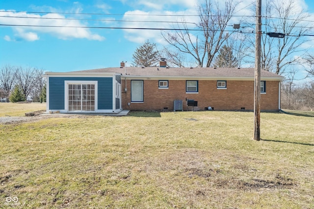 rear view of house featuring central AC unit, a yard, a chimney, crawl space, and brick siding