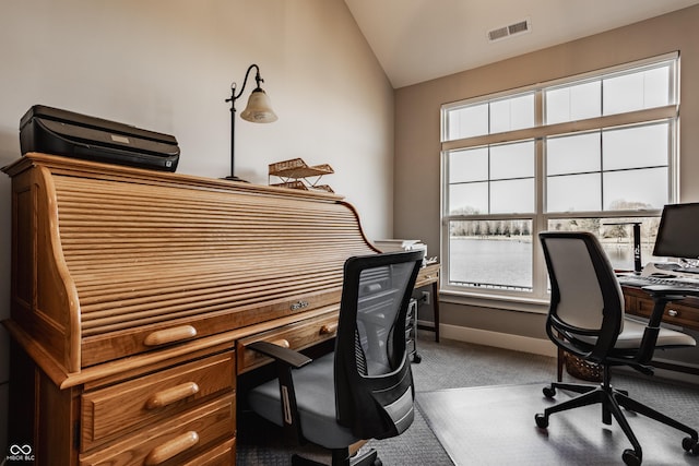 carpeted office featuring visible vents, baseboards, and lofted ceiling