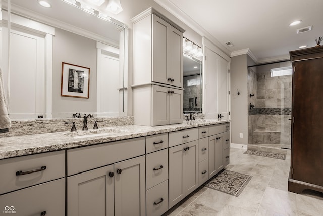 full bathroom with a sink, visible vents, tiled shower, and crown molding