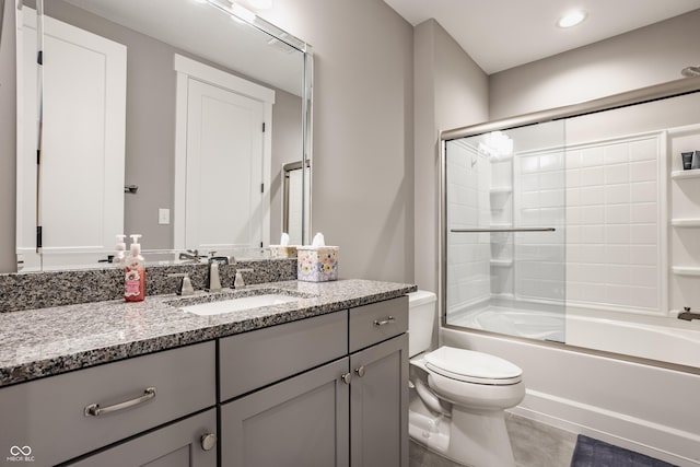 full bathroom featuring combined bath / shower with glass door, toilet, and vanity