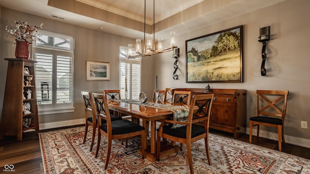 dining area with a healthy amount of sunlight, baseboards, a tray ceiling, and wood finished floors