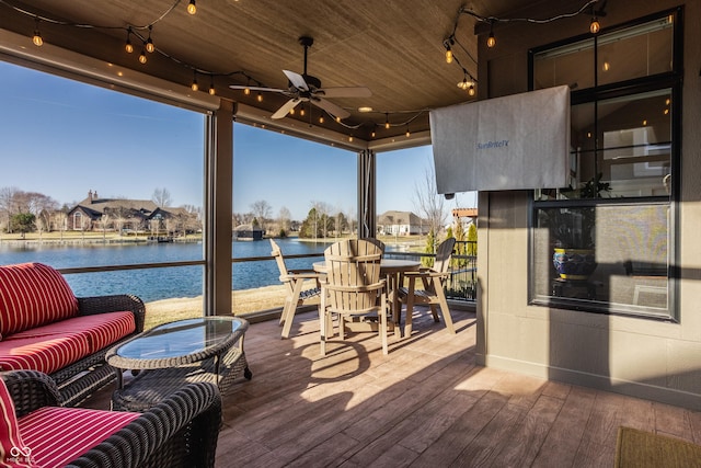 deck with a water view and a ceiling fan