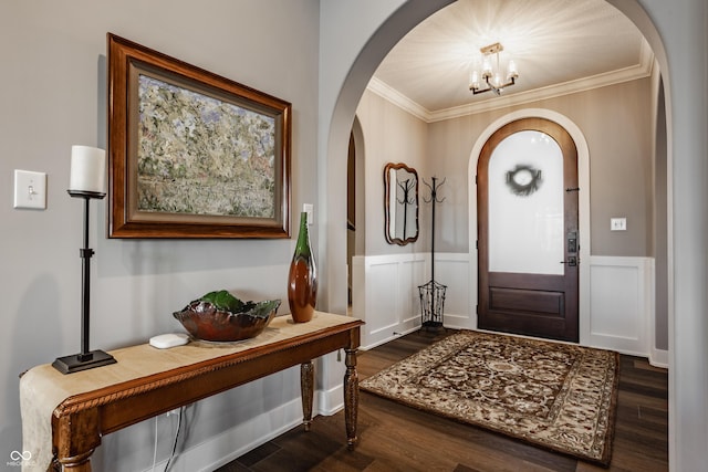 foyer with a wainscoted wall, arched walkways, dark wood-style flooring, and crown molding