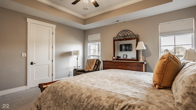 bedroom featuring visible vents, ornamental molding, a tray ceiling, carpet floors, and baseboards