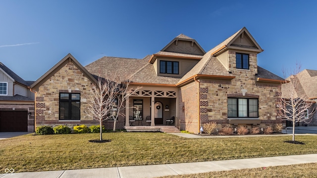 view of front of house with stone siding, brick siding, roof with shingles, and a front yard