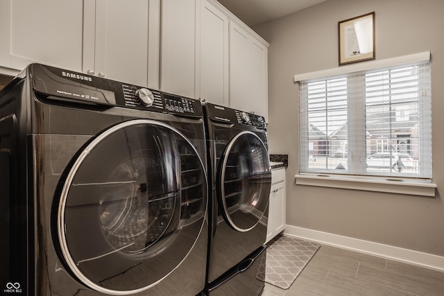 laundry room with cabinet space, washer and dryer, and baseboards