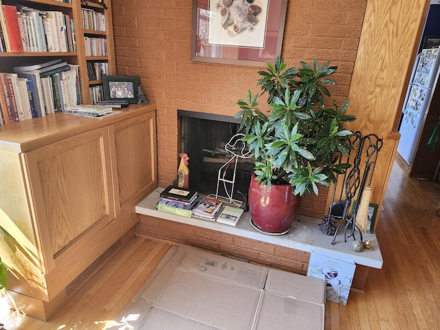 room details with a brick fireplace and wood finished floors