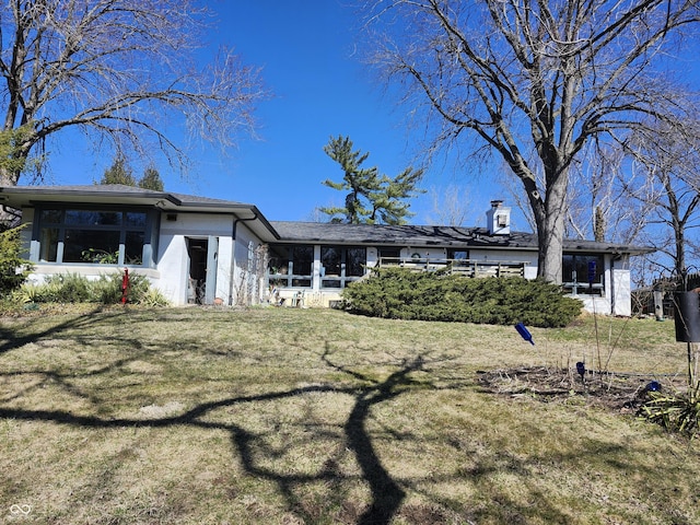 rear view of house featuring a lawn