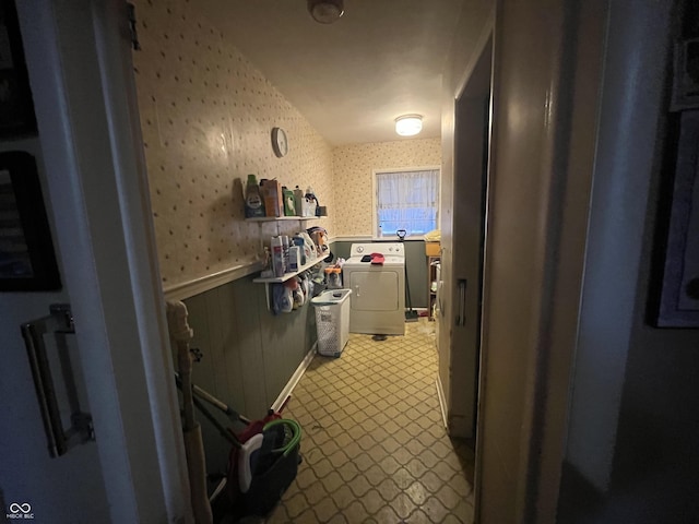 corridor featuring a wainscoted wall, separate washer and dryer, and wallpapered walls