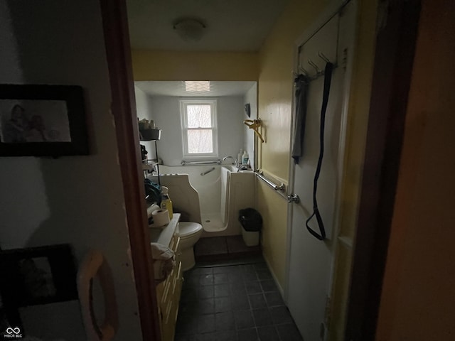 bathroom featuring tile patterned floors, a bathing tub, and toilet