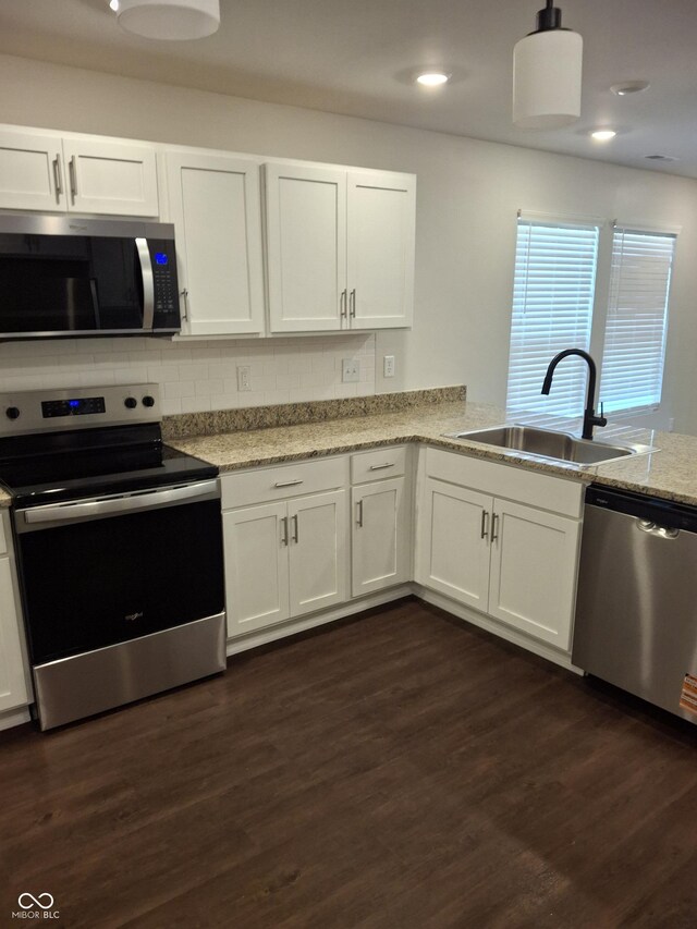 1974 Ralston Ave, Indianapolis, IN 46218 - kitchen featuring stainless steel appliances, white cabinets, dark wood-type flooring, backsplash, and recessed lighting