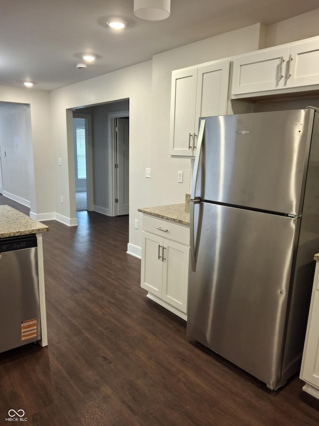1974 Ralston Ave, Indianapolis, IN 46218 - kitchen with appliances with stainless steel finishes, dark wood-type flooring, white cabinets, light stone countertops, and recessed lighting