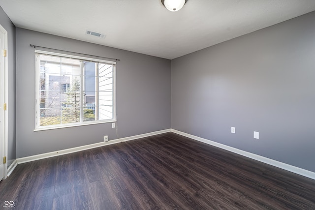 unfurnished room featuring visible vents, baseboards, and wood finished floors