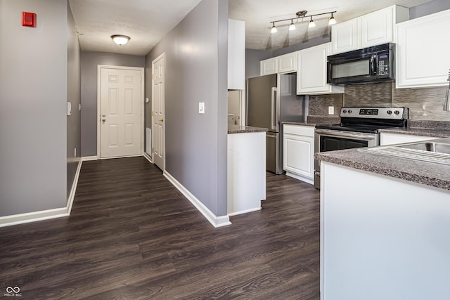 kitchen featuring white cabinetry, dark countertops, dark wood-style floors, and appliances with stainless steel finishes