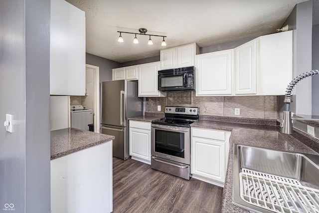 kitchen featuring a sink, washer / dryer, dark countertops, and stainless steel appliances