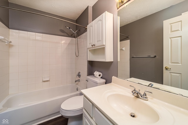 bathroom with toilet, a textured ceiling, wood finished floors, tub / shower combination, and vanity