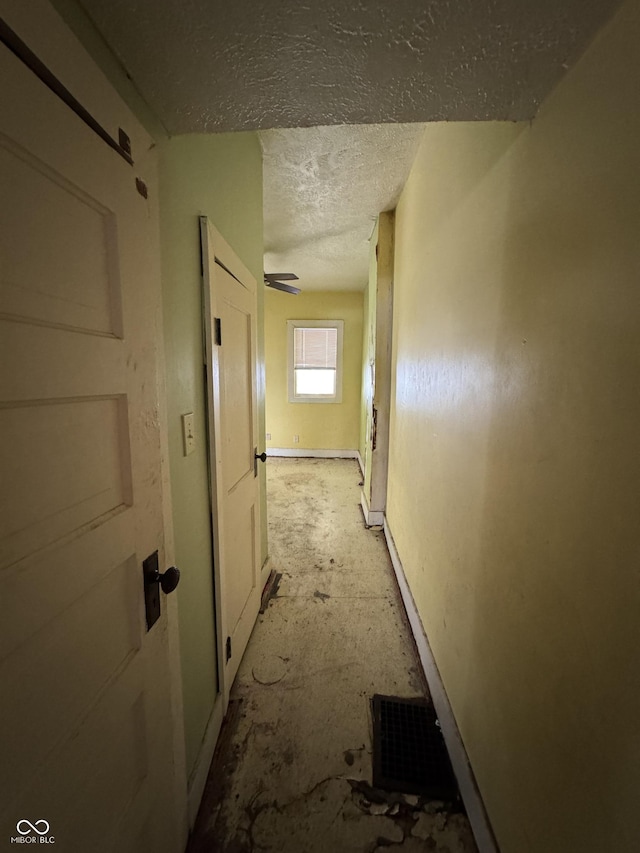 hall with a textured ceiling