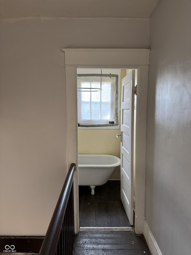 full bathroom featuring a soaking tub and hardwood / wood-style floors