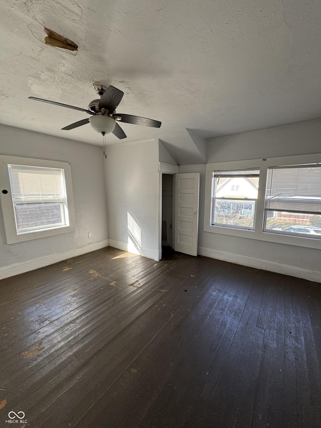 interior space with baseboards, dark wood-style flooring, and a textured ceiling