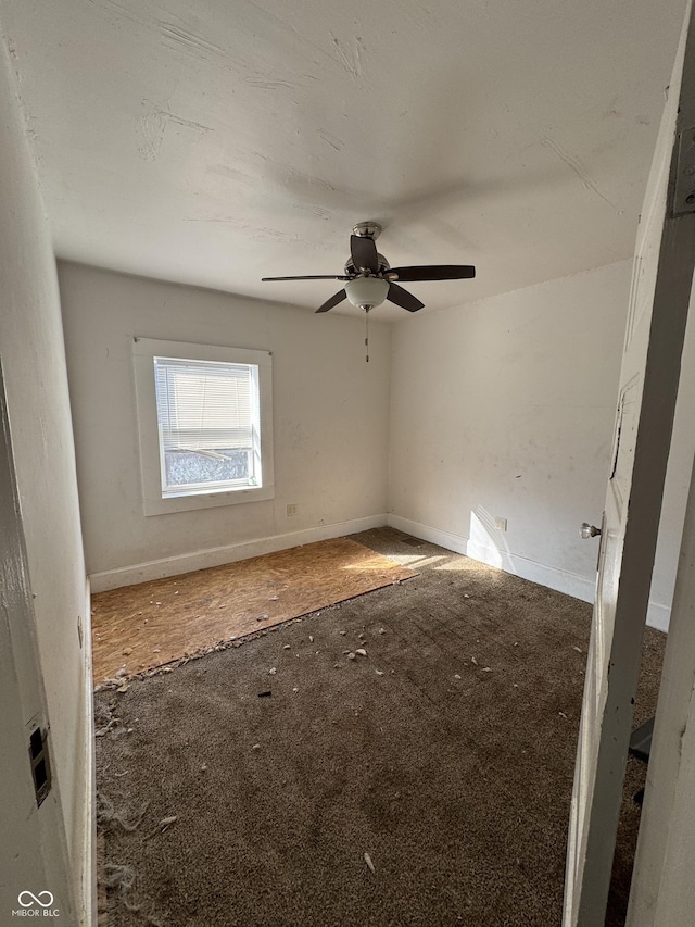 empty room featuring a ceiling fan and baseboards