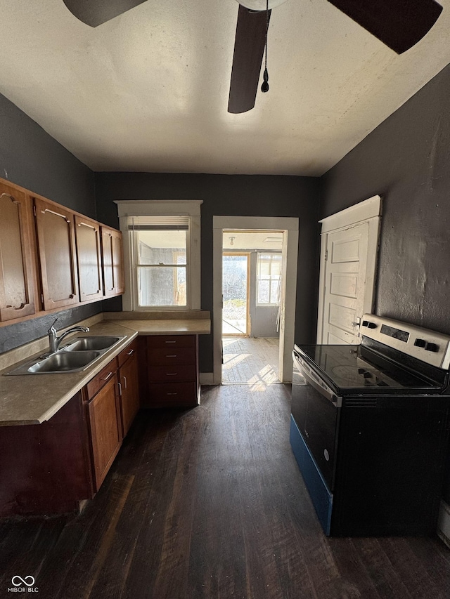 kitchen featuring a sink, dark wood-type flooring, a textured ceiling, and electric stove