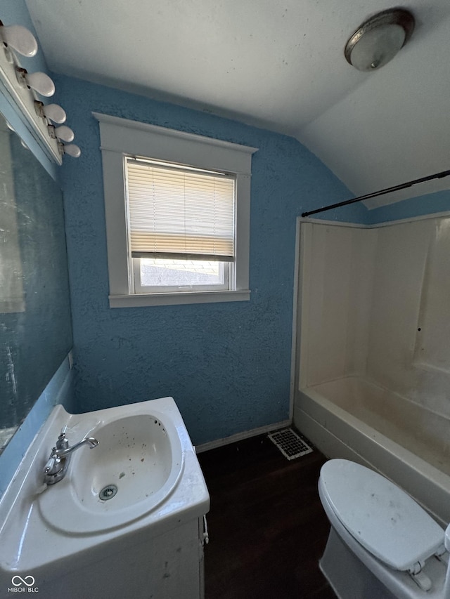 full bath with baseboards, shower / washtub combination, toilet, lofted ceiling, and vanity