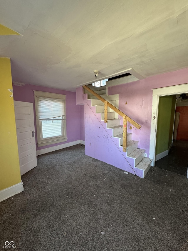 below grade area with carpet flooring, baseboards, and stairs