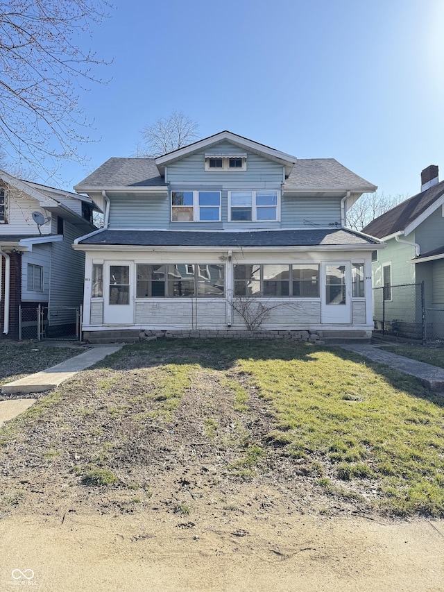 view of front of home with a front lawn and a sunroom