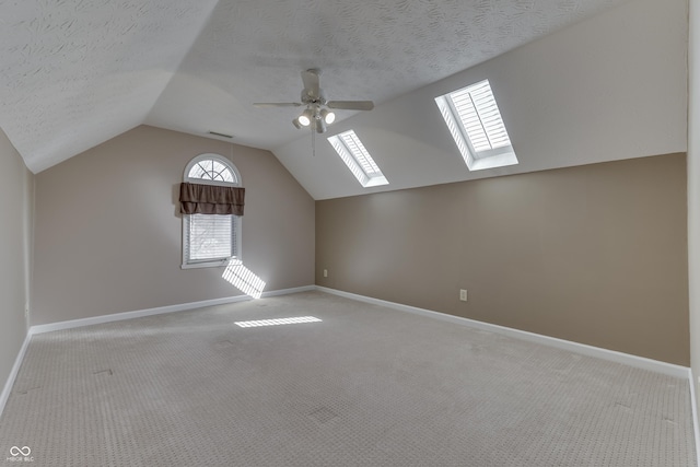 bonus room with a textured ceiling, carpet, baseboards, ceiling fan, and vaulted ceiling