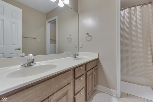 bathroom with tile patterned floors, double vanity, baseboards, and a sink