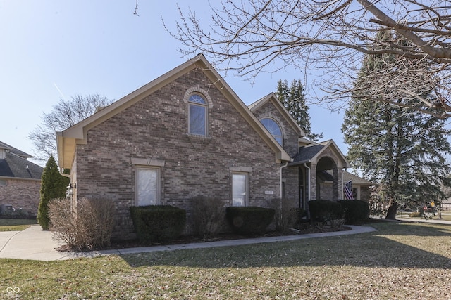 view of front of house featuring brick siding and a front yard