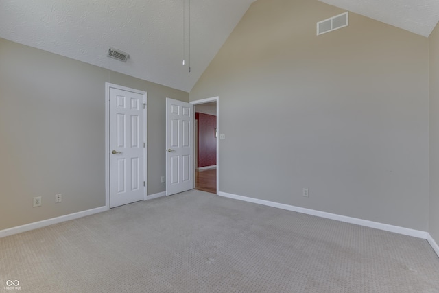 unfurnished bedroom featuring light carpet, visible vents, high vaulted ceiling, and baseboards