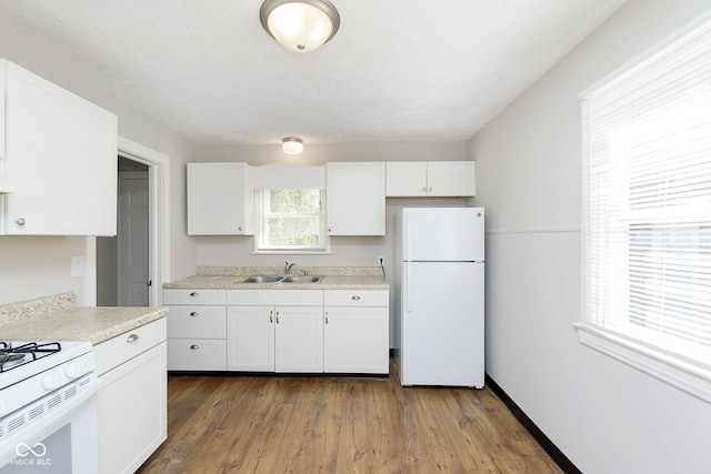 kitchen with white appliances, dark wood-style floors, a sink, light countertops, and white cabinetry