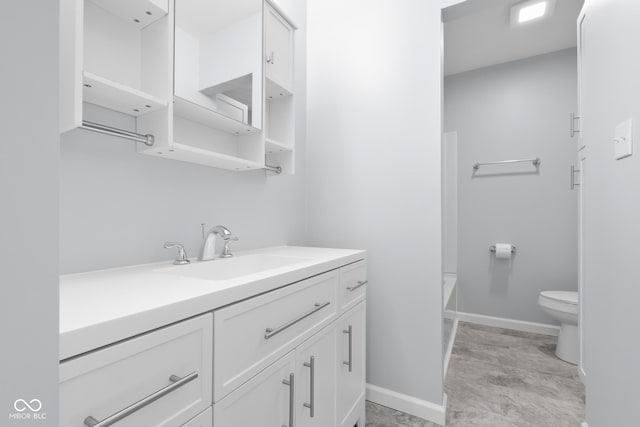 bathroom featuring vanity, toilet, and baseboards