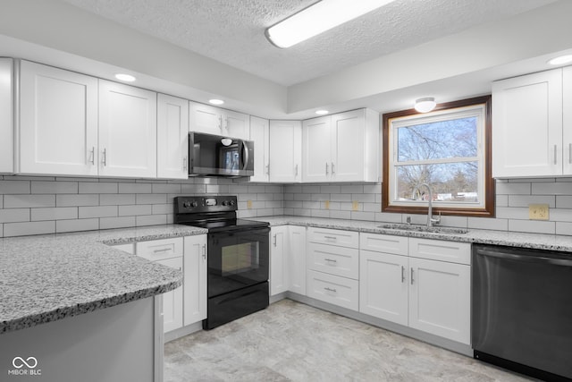 kitchen with stainless steel dishwasher, black electric range, white cabinetry, and a sink